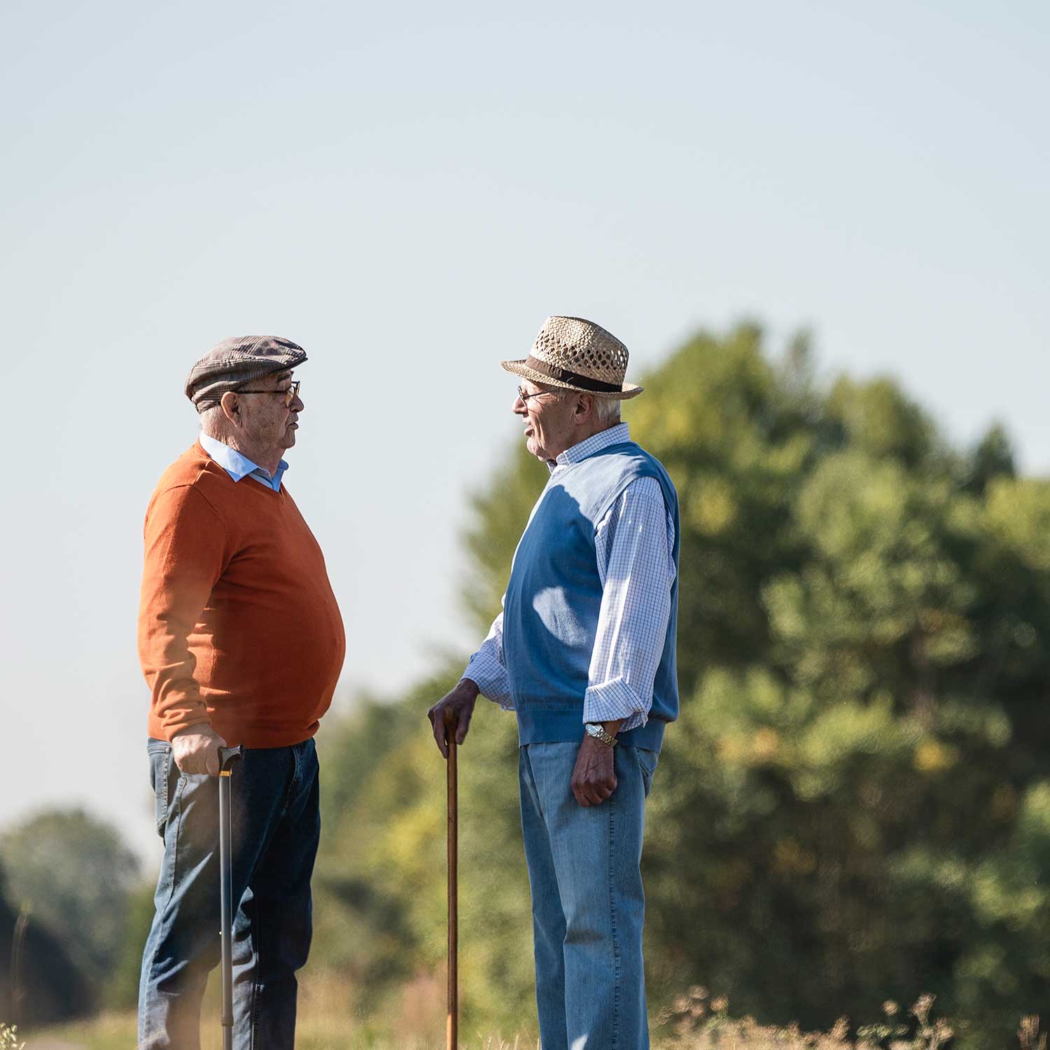2 older men in a field talking
